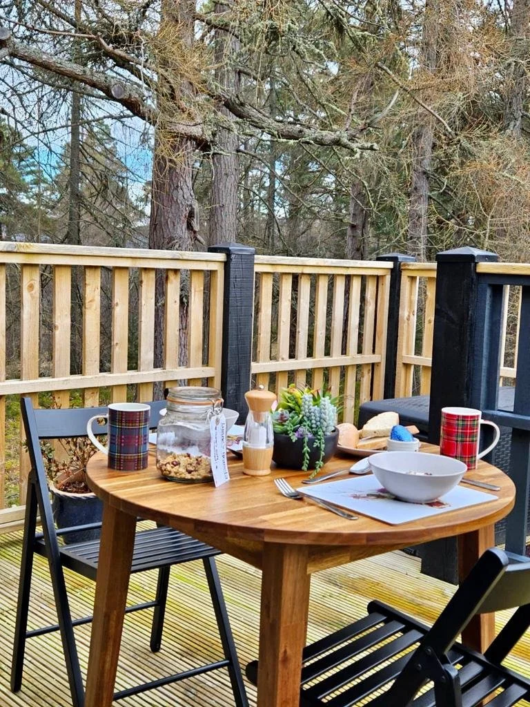 Outdoor breakfast table for two on The Hayloft deck, overlooking the surrounding woodland.
