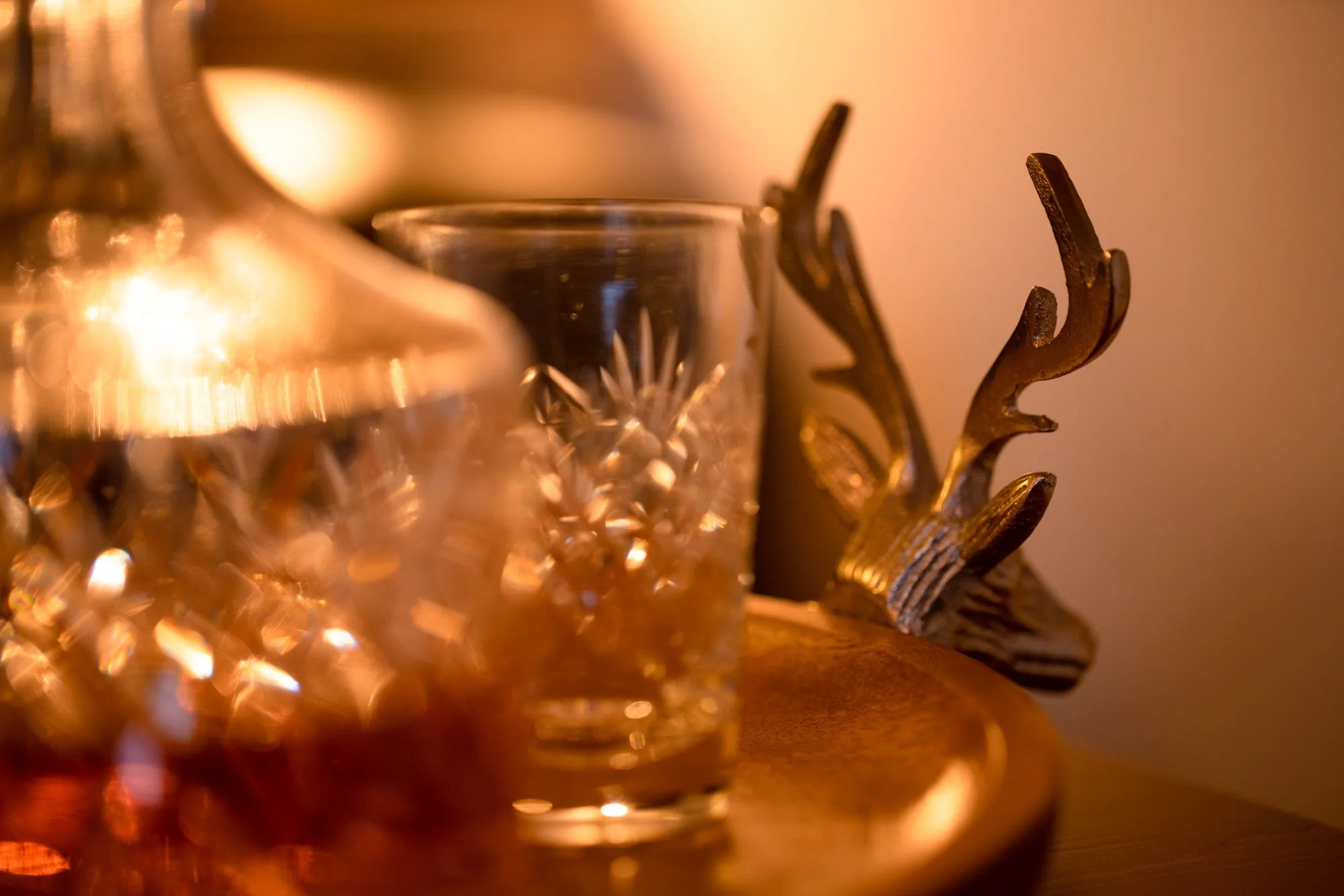 Whisky glasses and decorative stag detail creating a cosy Highland feel at The Hayloft.