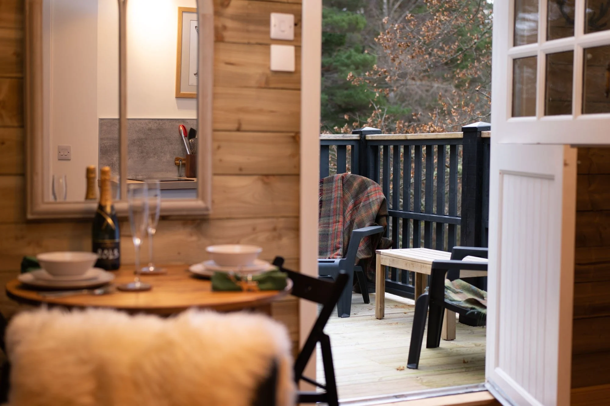 Open doors from The Hayloft living space leading onto the private woodland deck.