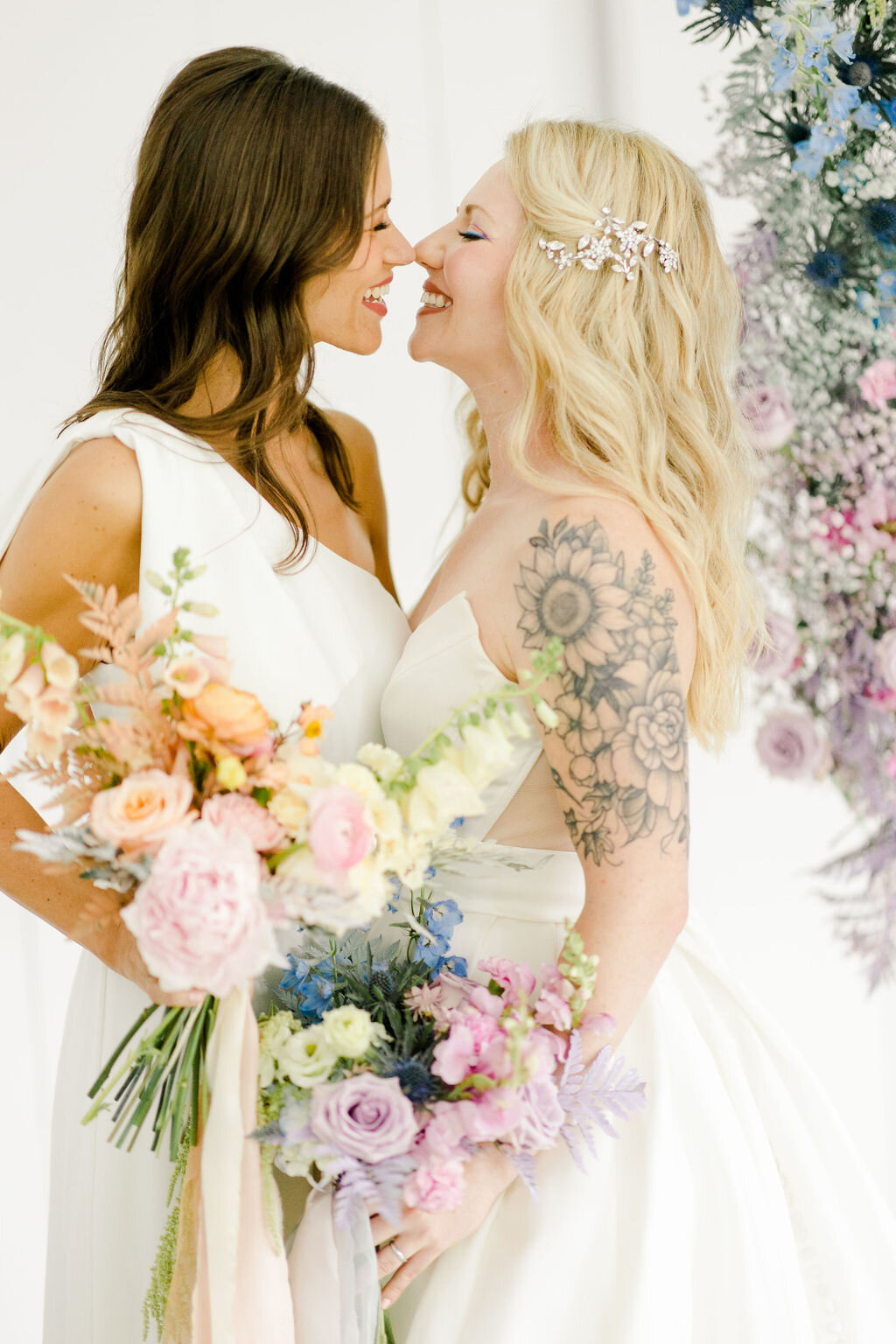 Brides holding colorful bridal bouquets wearing Ines Di Santo Quice and the Windham Jumpsuit.