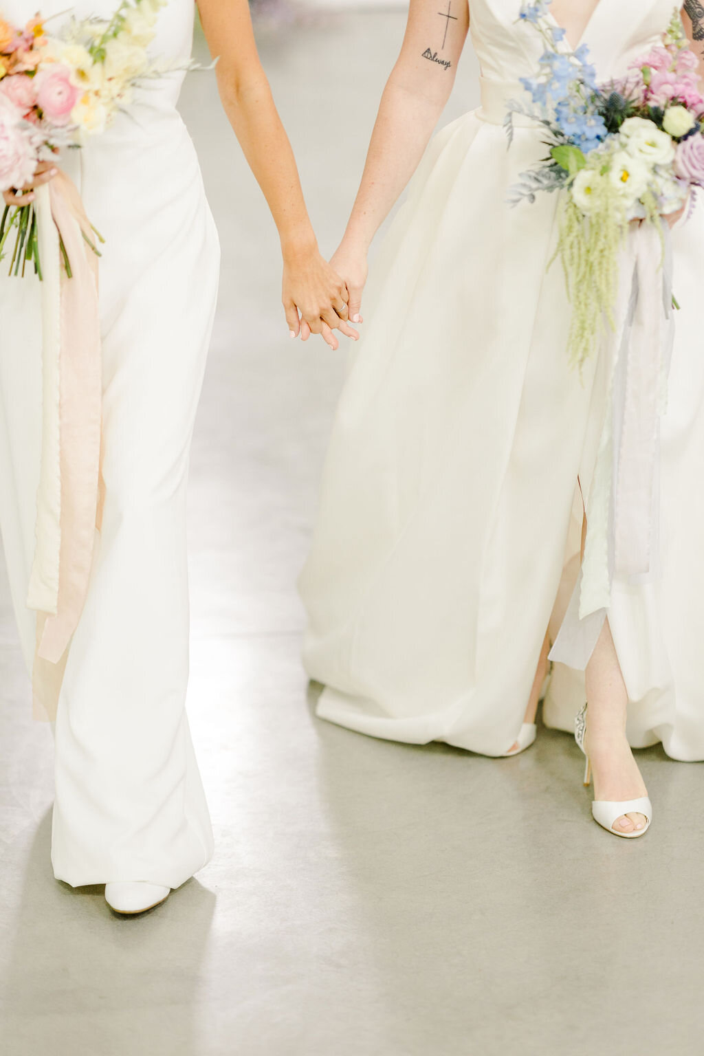 Brides holding colorful bridal bouquets wearing Ines Di Santo Quice and the Windham Jumpsuit.