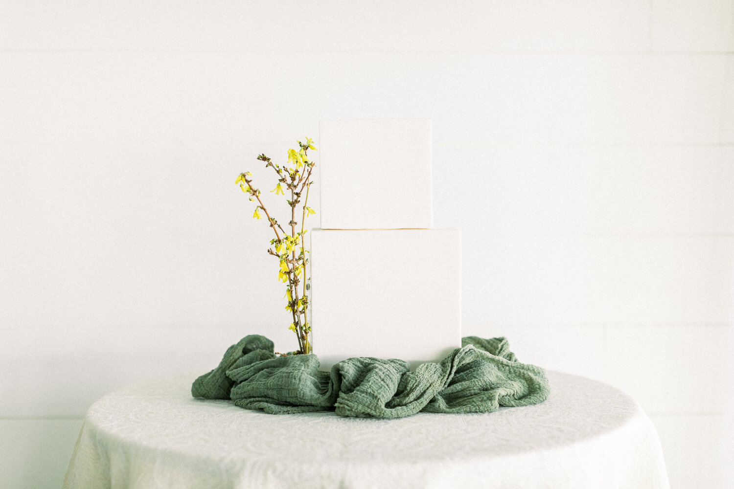Minimalistic white wedding cake with yellow florals.