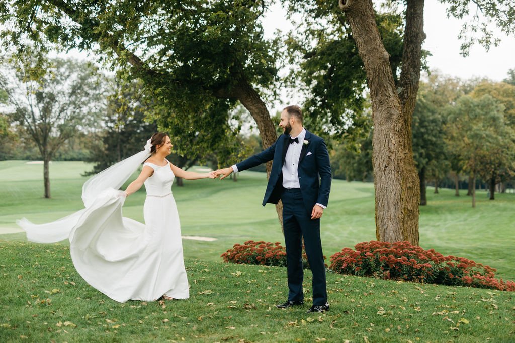 bride and groom standing outside posing for wedding pictures