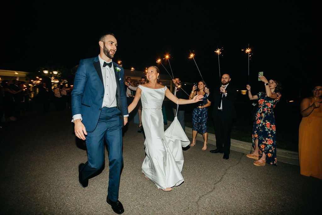 bride and groom leaving wedding reception with sparklers
