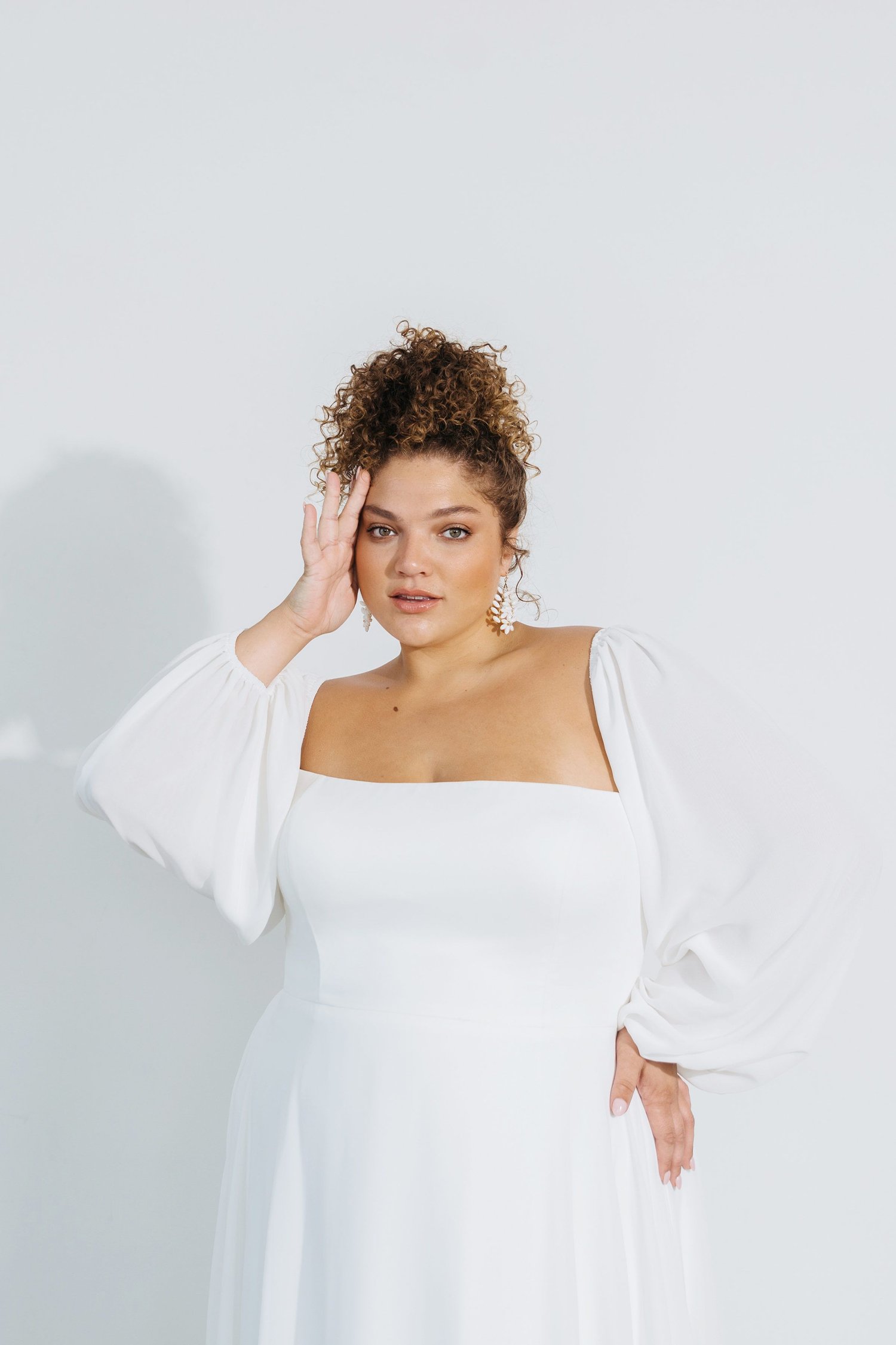 woman wearing Jenny Yoo Louise a line long sleeve wedding dress