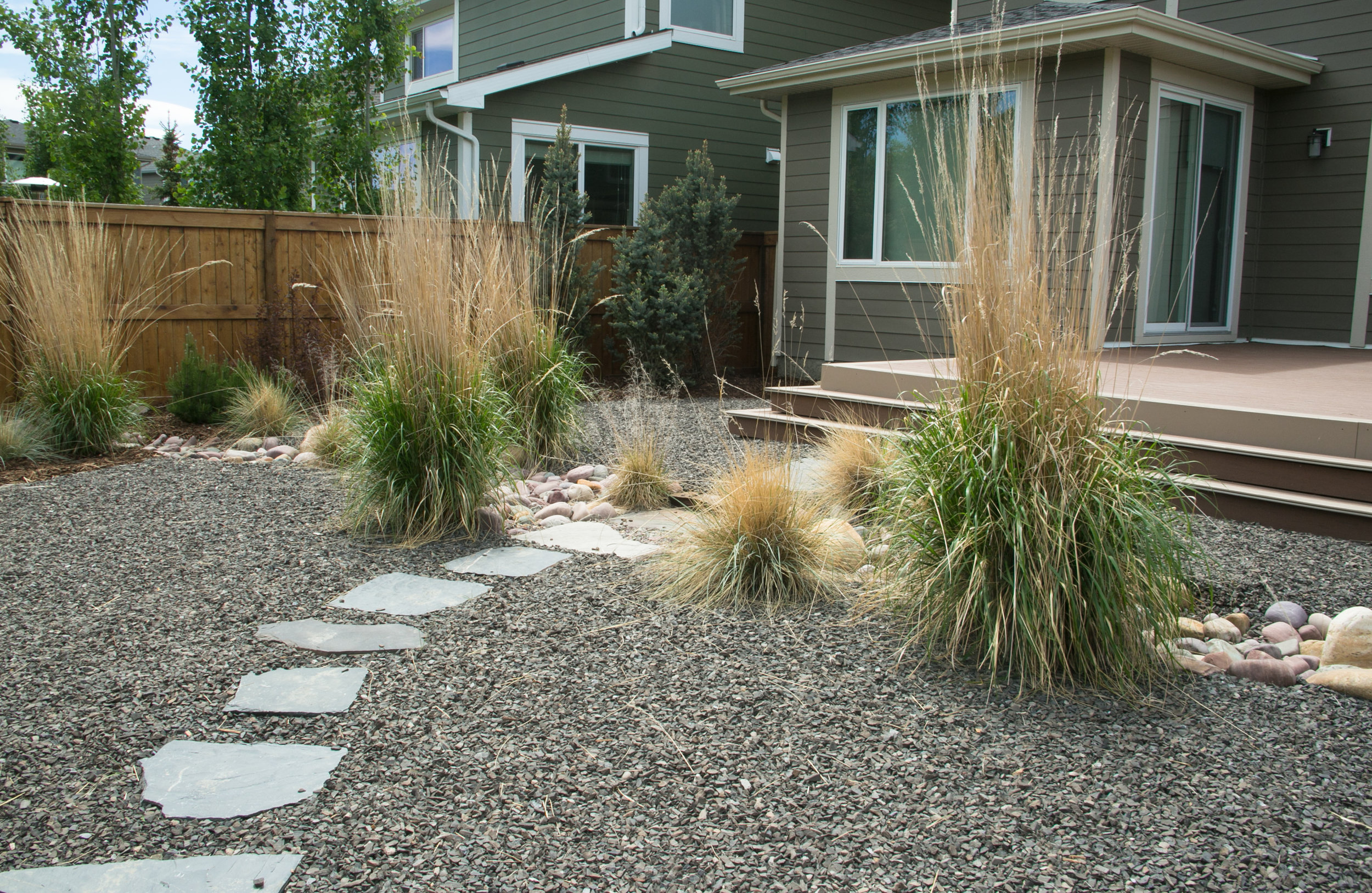  Xerascaped yard with paving stone pathway and composite deck — Cranston, Calgary. 