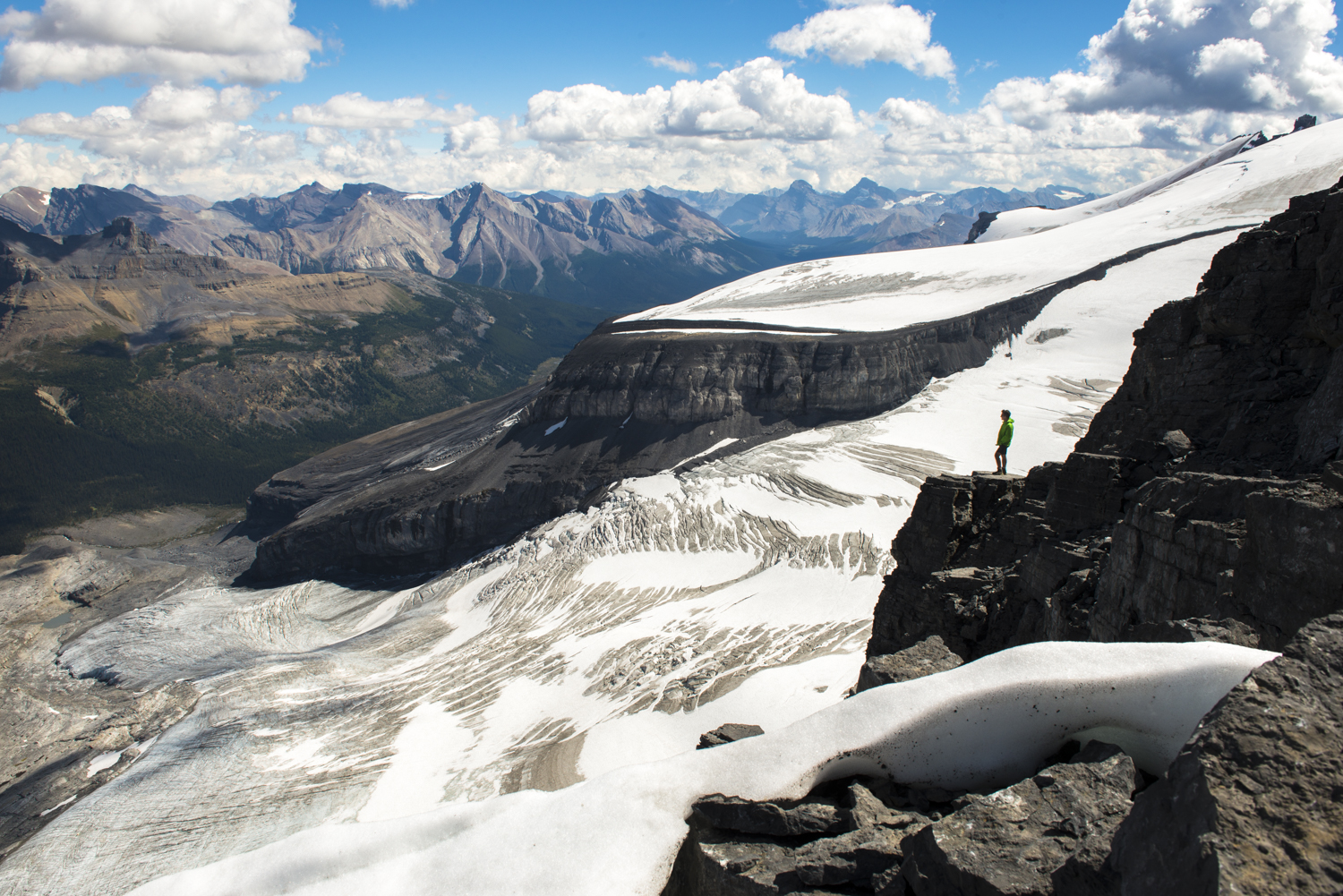 A hiker is rewarded with magnificent views of surounding glaciers on Little Hector Peak.