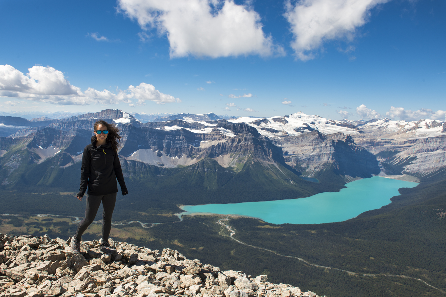 A hiker poses in front of Hector Lake.