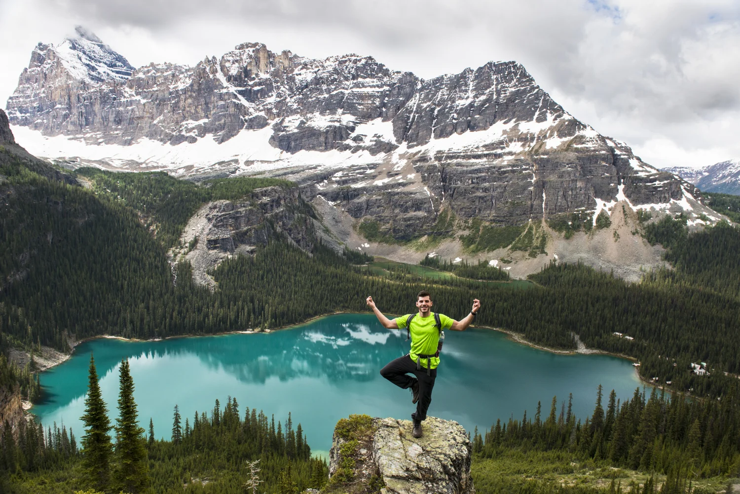A hiker poses in front of Lake O'hara.