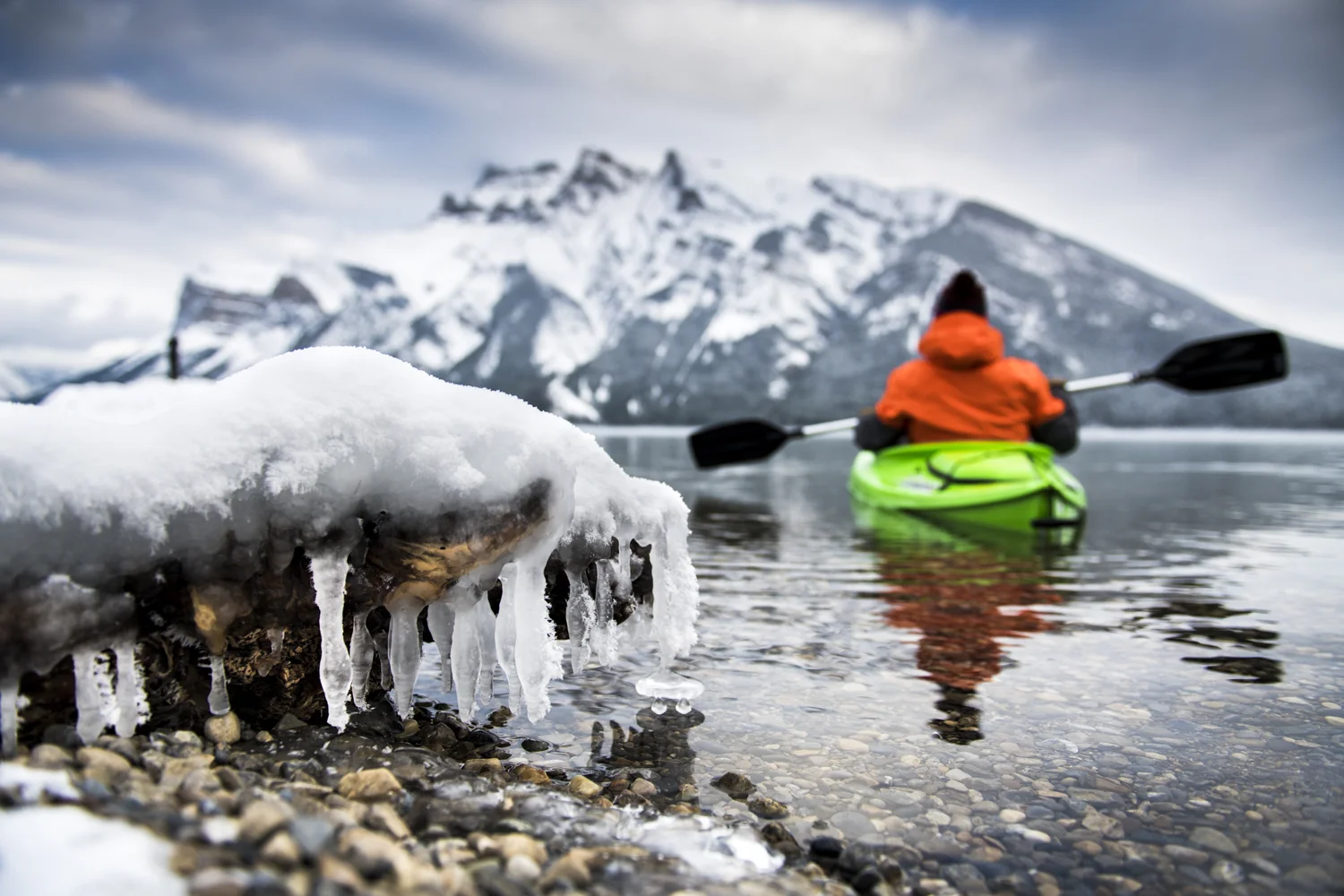 A kayaker embraces colder temperatures for a scenic paddle on Lake Minewanka