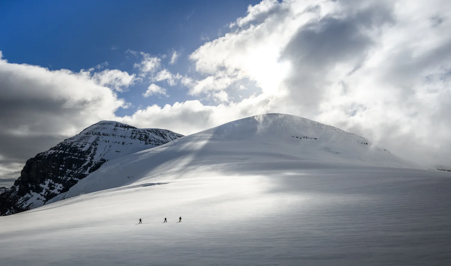 Three friends ski tour above the Athabasca Glacier towards Snow Dome
