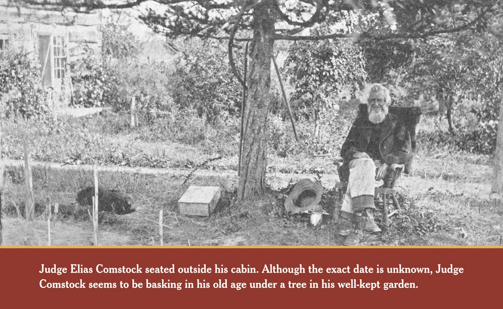CONTENTMENT: Judge Elias Comstock stead outside his cabin. Although the exact date of this photo is unknown, Judge Comstock seems to be basking in his old age under a tree in his well-kept garden.