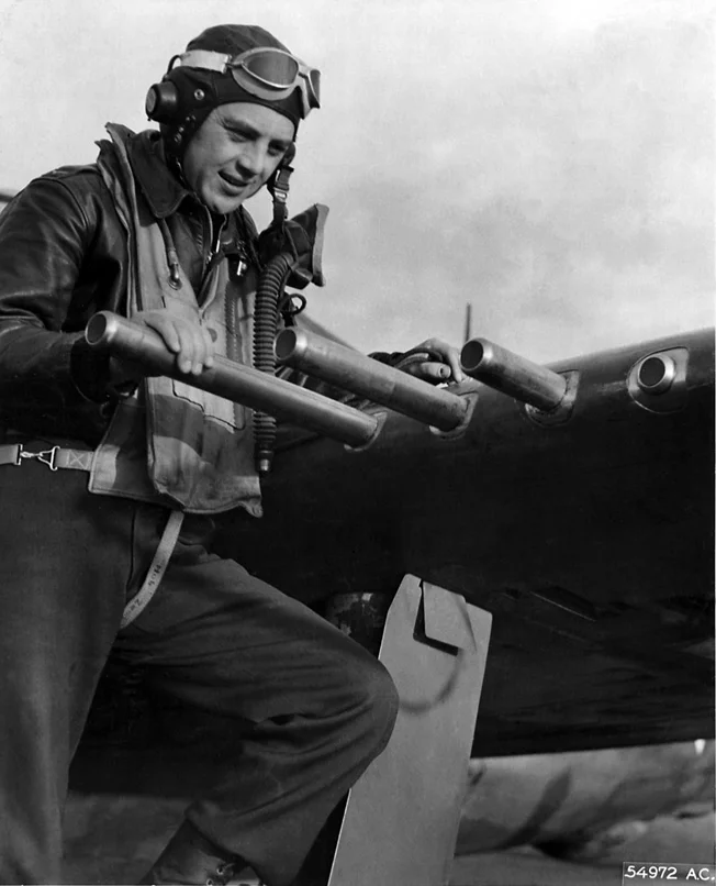 Examining the .50 caliber machine guns on his P-47C Thunderbolt.