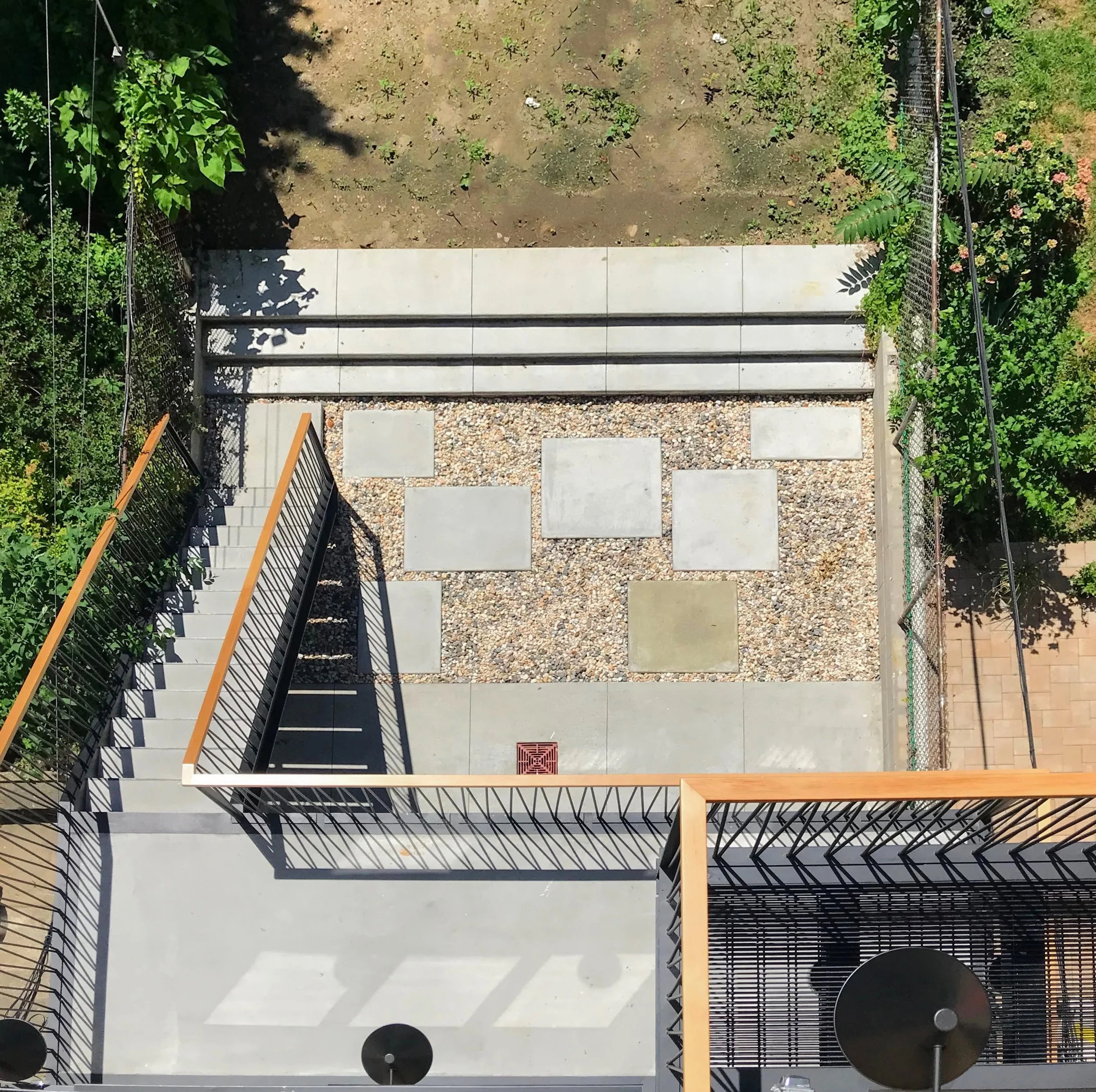 In the backyard, a gravel basin was engineered to naturally retain and slowly dissipate rainwater in this flood-prone zone.