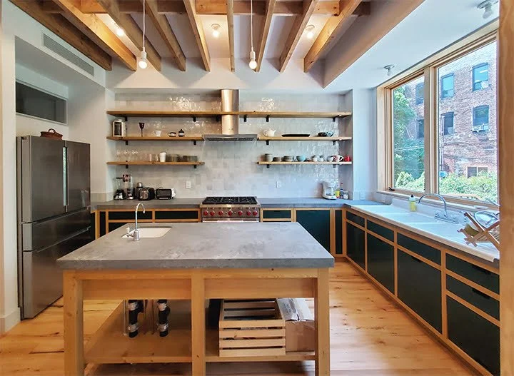 The kitchen cabinets, island, and shelves were custom-built using wood reclaimed from the original ceiling beams that required replacement.
