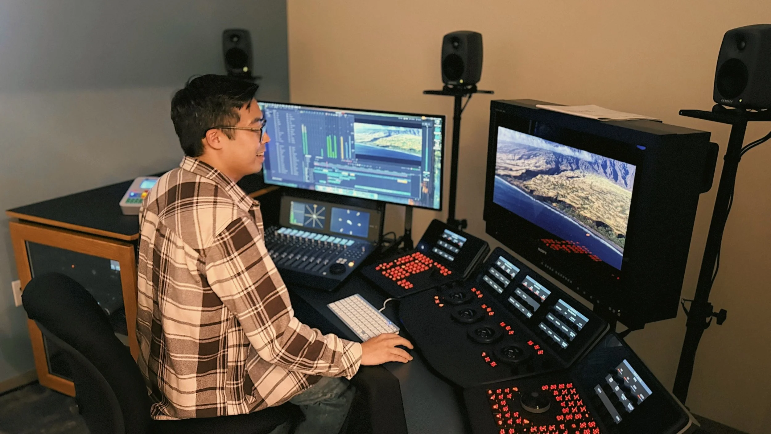 Quincy Woo, videographer and film & video editor based Portland Oregon, sitting at an editing bay.