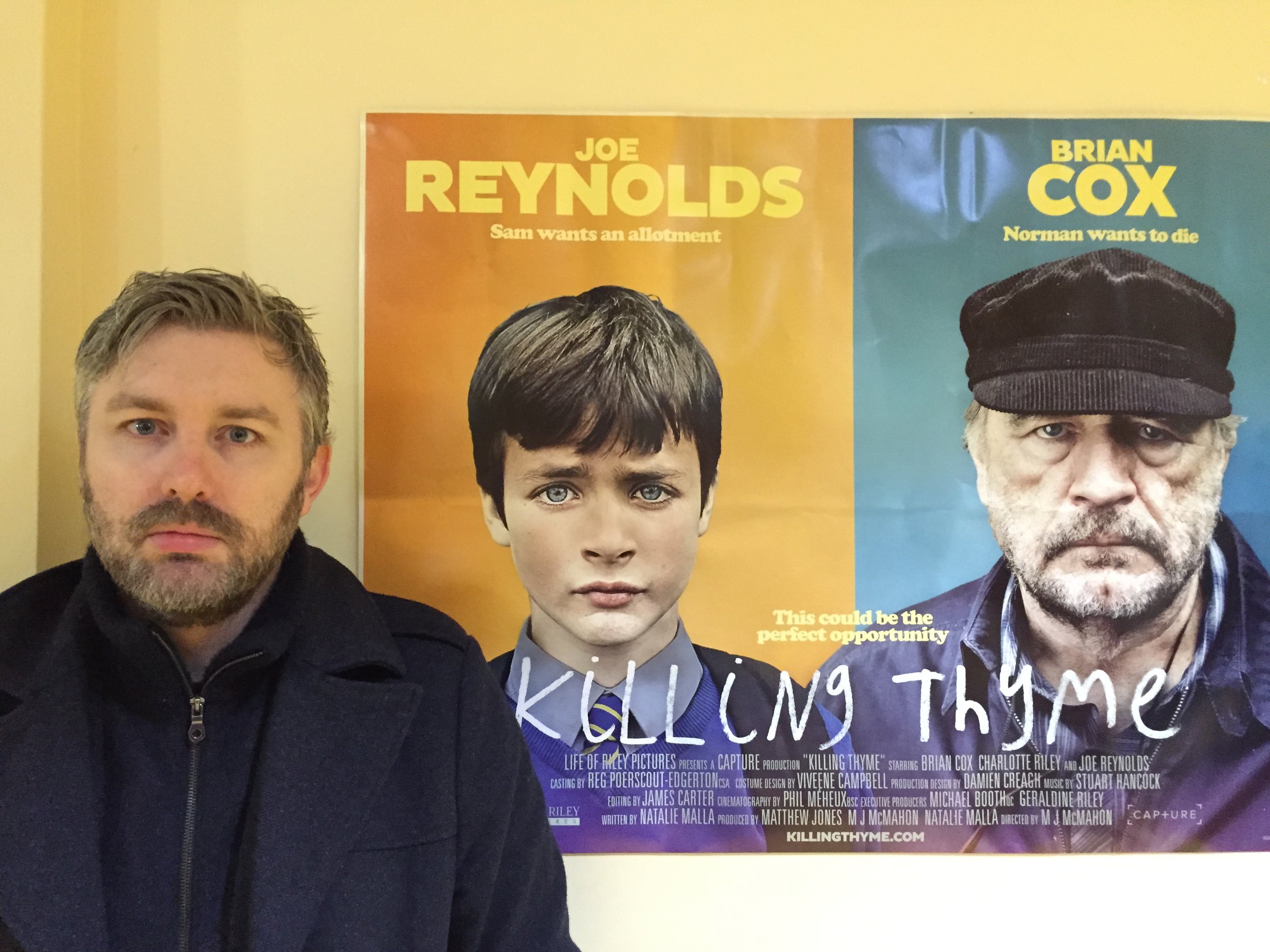 M J McMahon in front of Killing Thyme poster