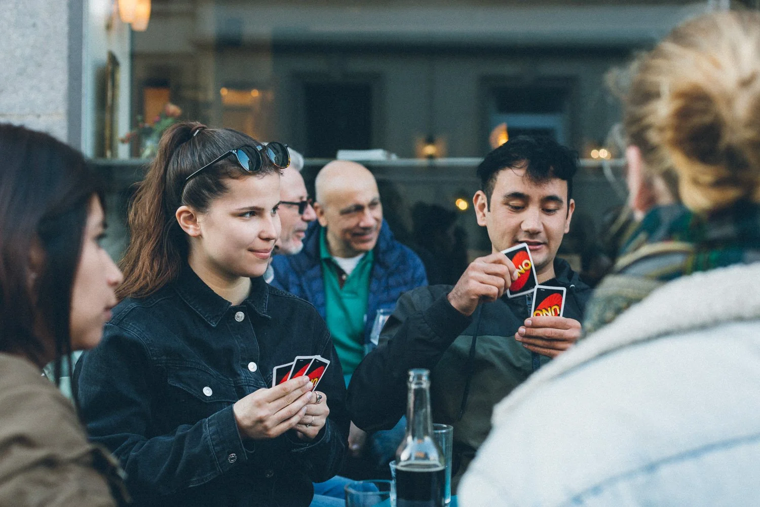 Smiling participants of Sprachcafé Basel playing Uno at Café Frühling in Basel