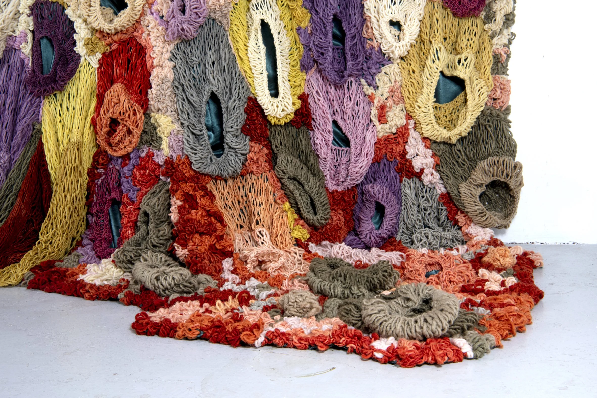 Ikke her. Ikke borte. (Not here. Not gone.) (2022)   Embroidery and knit on satin. Natural dyed yarn (pine cones, pine tree, avocado, cochenial insect, spinach, birch, madder, rhubarb, tree lichens). Wood.  4,04x3,28m