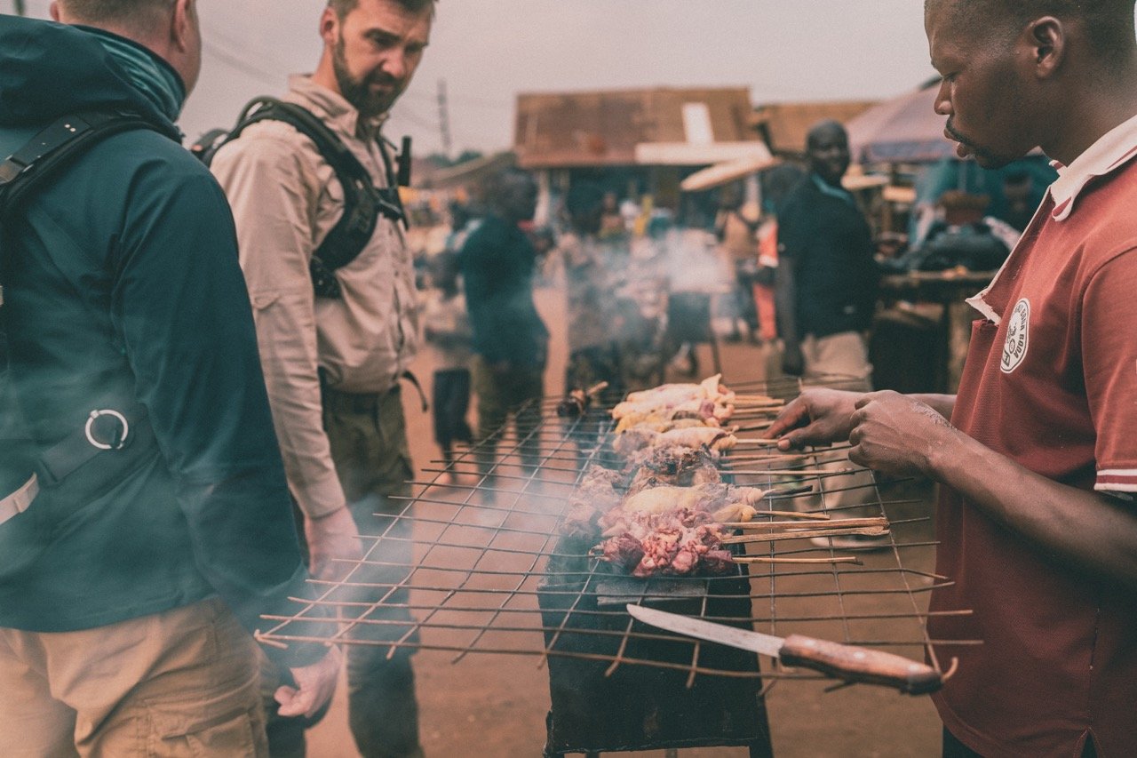 Adventure motorcycle rider enjoys street food Uganda