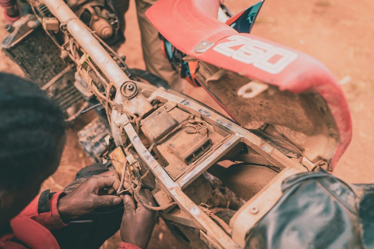 Ugandan motorcycle mechanic fixing adventure bike