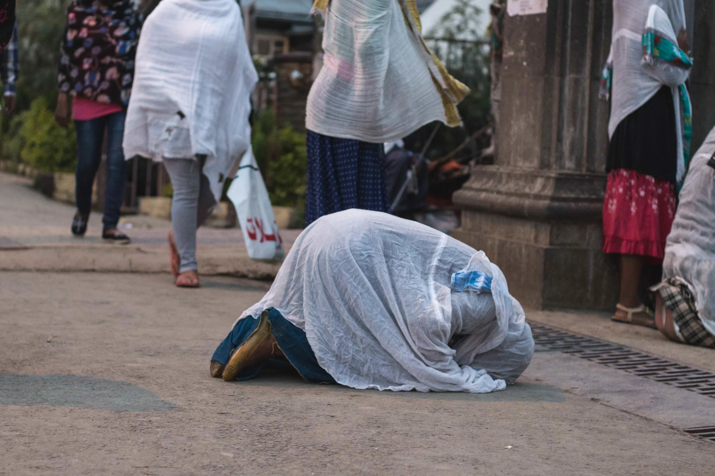 Woman praying in front of a church before she enters. 
