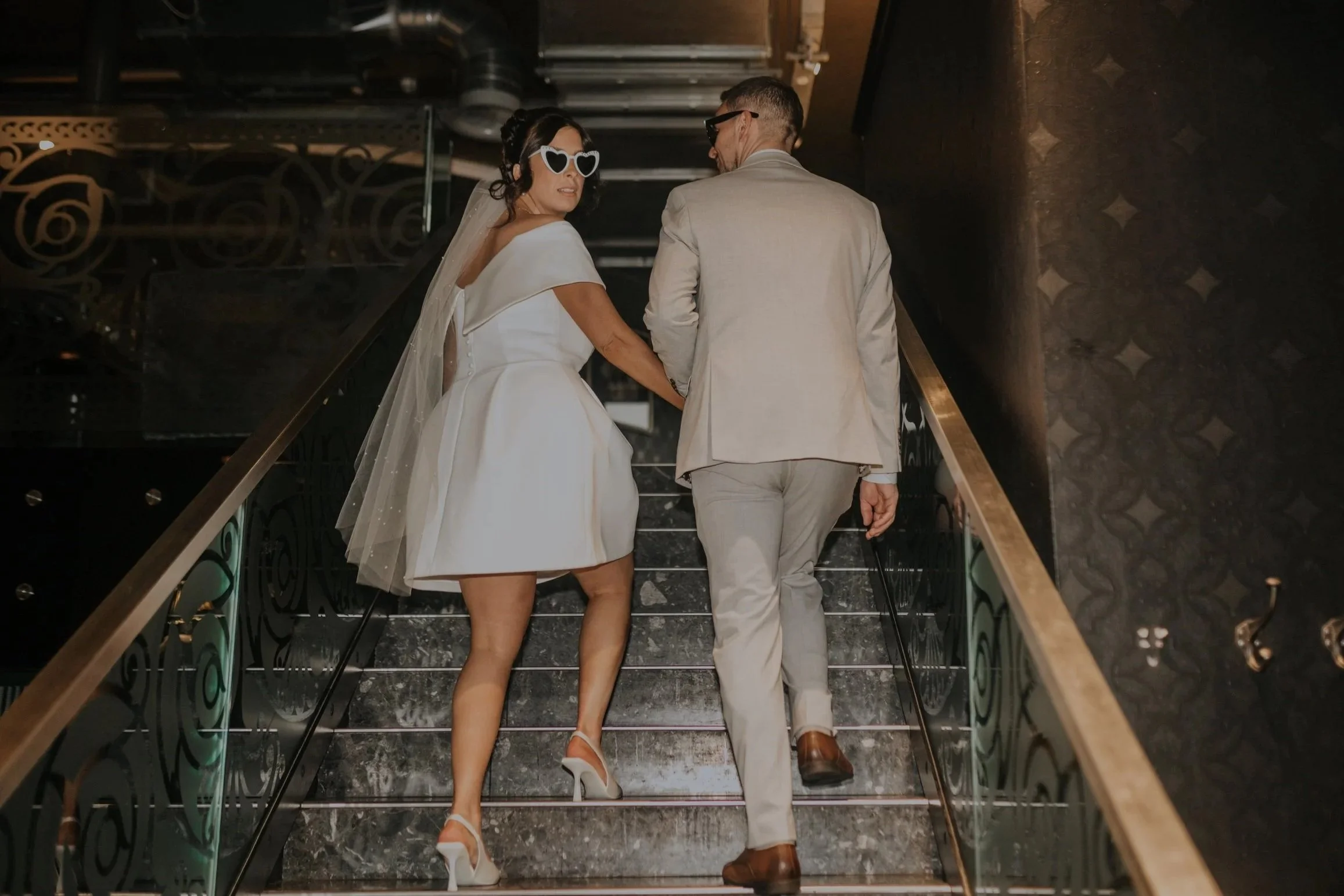 A couple kissing in a mountainous landscape with cloudy sky.