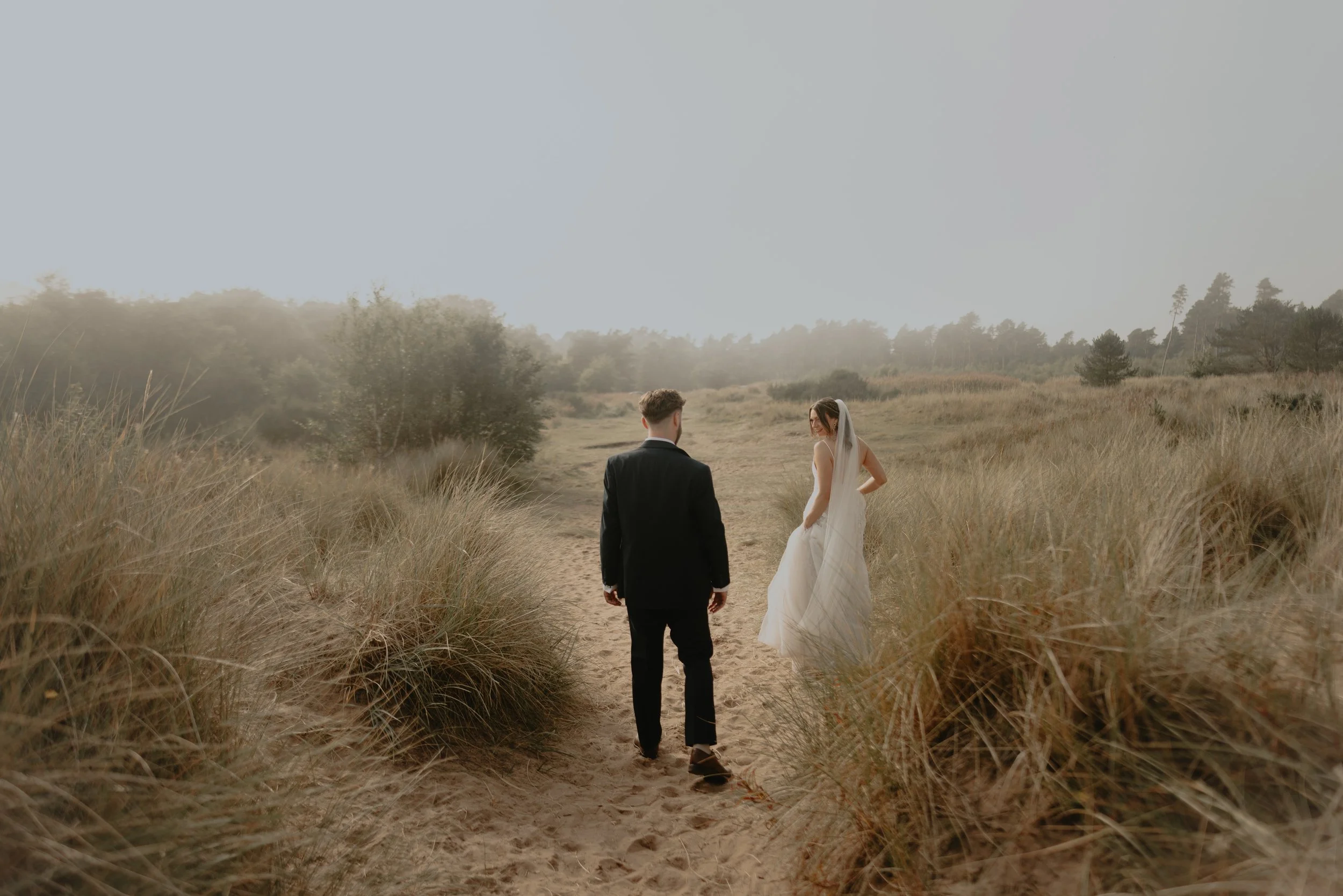 Jen and Aaron walking through the misty sandy dunes at Tentsmuir.