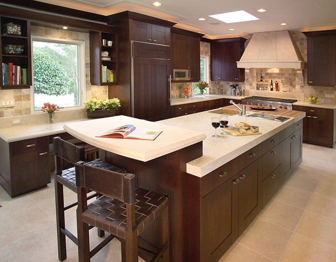 The dark cherry cabinetry gives strong contrast to the limestone counters.
