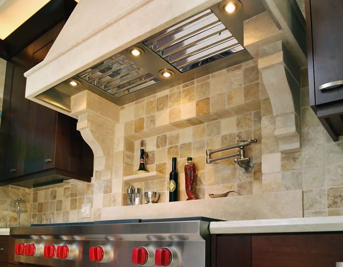 This custom limestone hood with commercial stainless liner integrates perfectly with the wall niche.