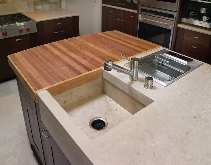 The end grain cherry butcher block abuts the custom stone sink and steamer.
