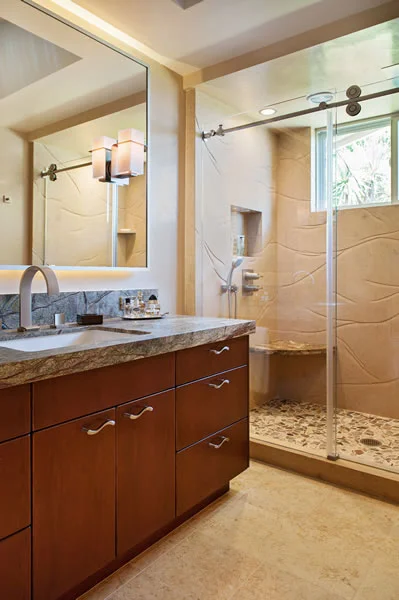 The richness of the cherry cabinetry and marble slabs gives contrast to the limestone shower and floor.