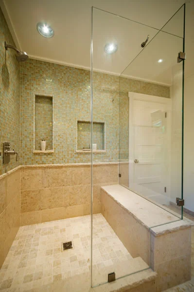The open feel of this room is enhanced by the continuation of the shower wall tiles across the entire wall.
