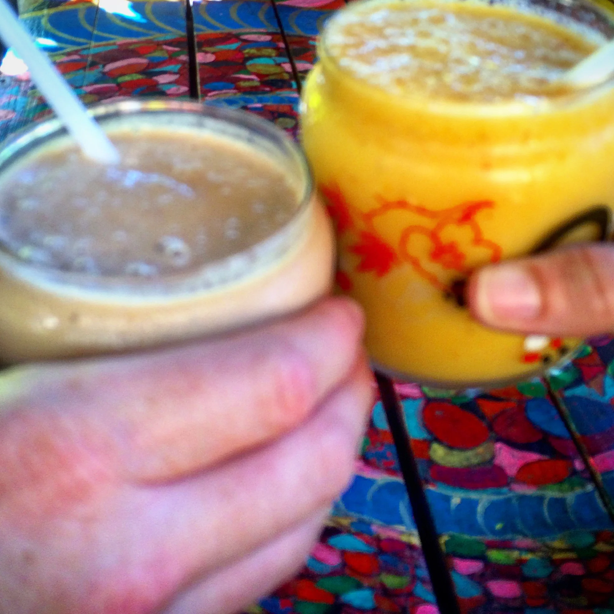 Cheers to your health! Left: Power protein smoothie with veg protein, banana, coconut milk, cinnamon, & cashew nuts. Right: Spicy Share: Pineapple, chili, lime juice, and mango.