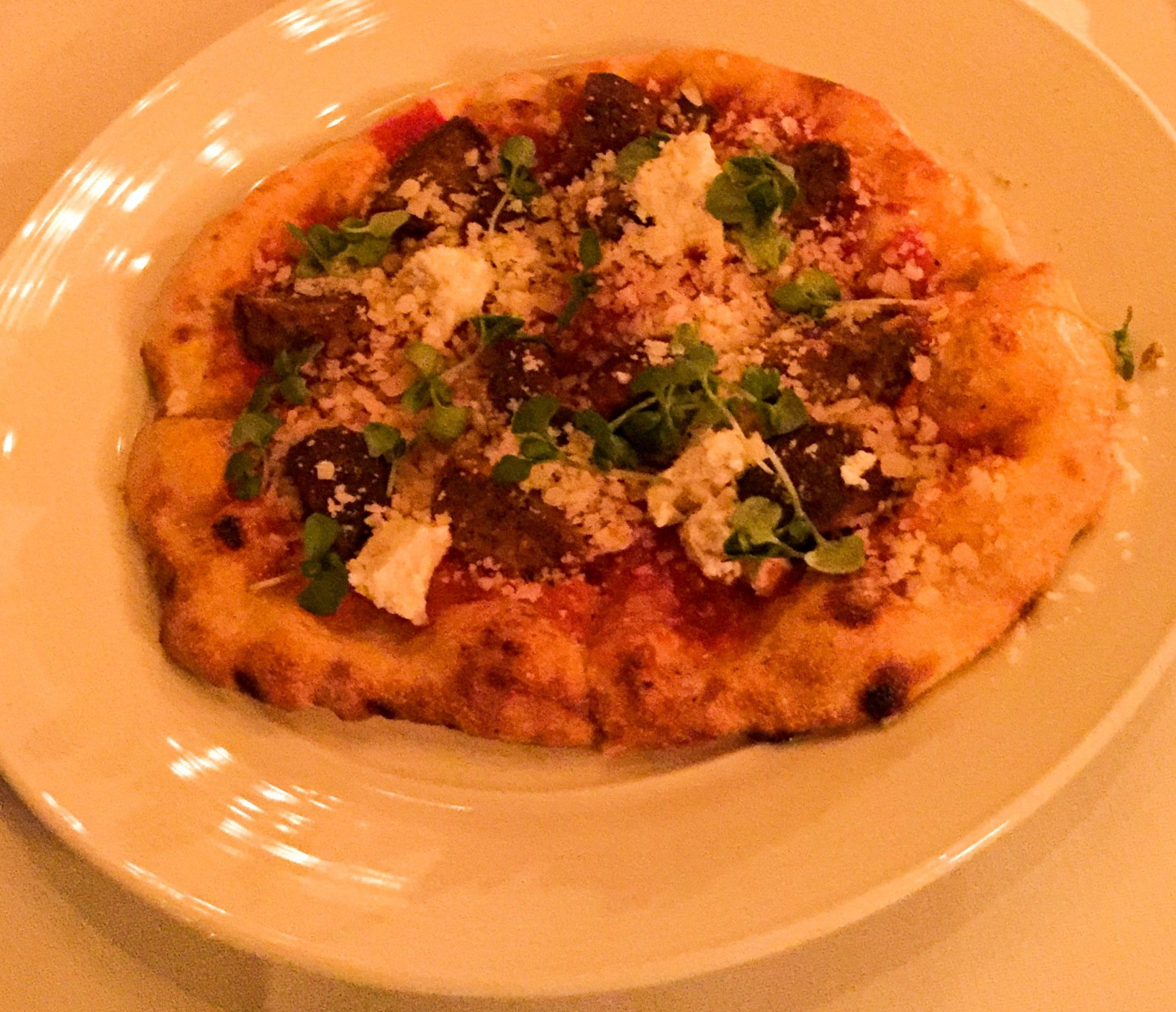 Spicy Meatball Pizza - House-made meatballs, calabrese peppers, almond ricotta, and micro basil.