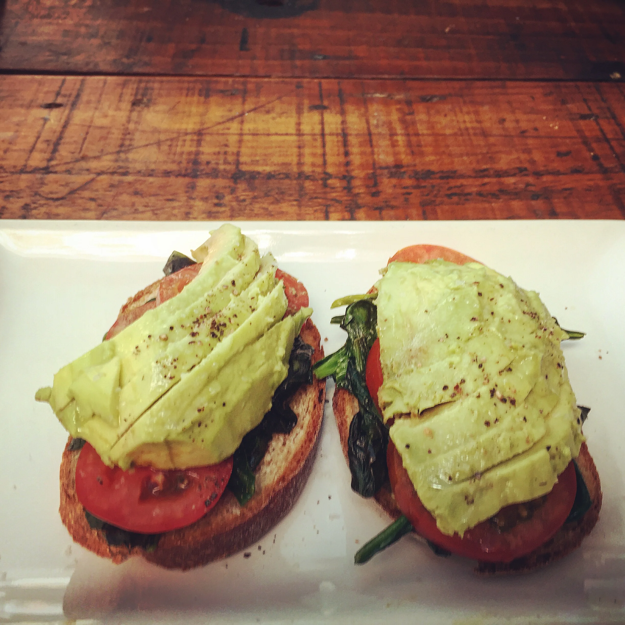 Avocado on Toast - Wheat bread, avocado, wilted spinach, fresh tomatoes and lime.