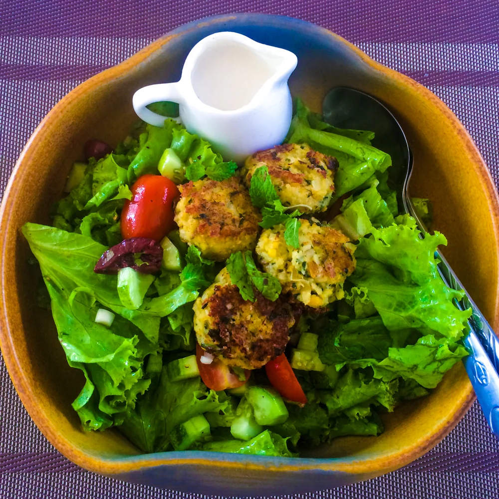 Make Falafel Not War Salad - Crispy cumin & coriander falafel with lettuce, tomato, red onion, cucumber, black olives & tahini garlic dressing.