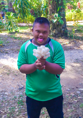 One of the students from the special school harvesting mushrooms.