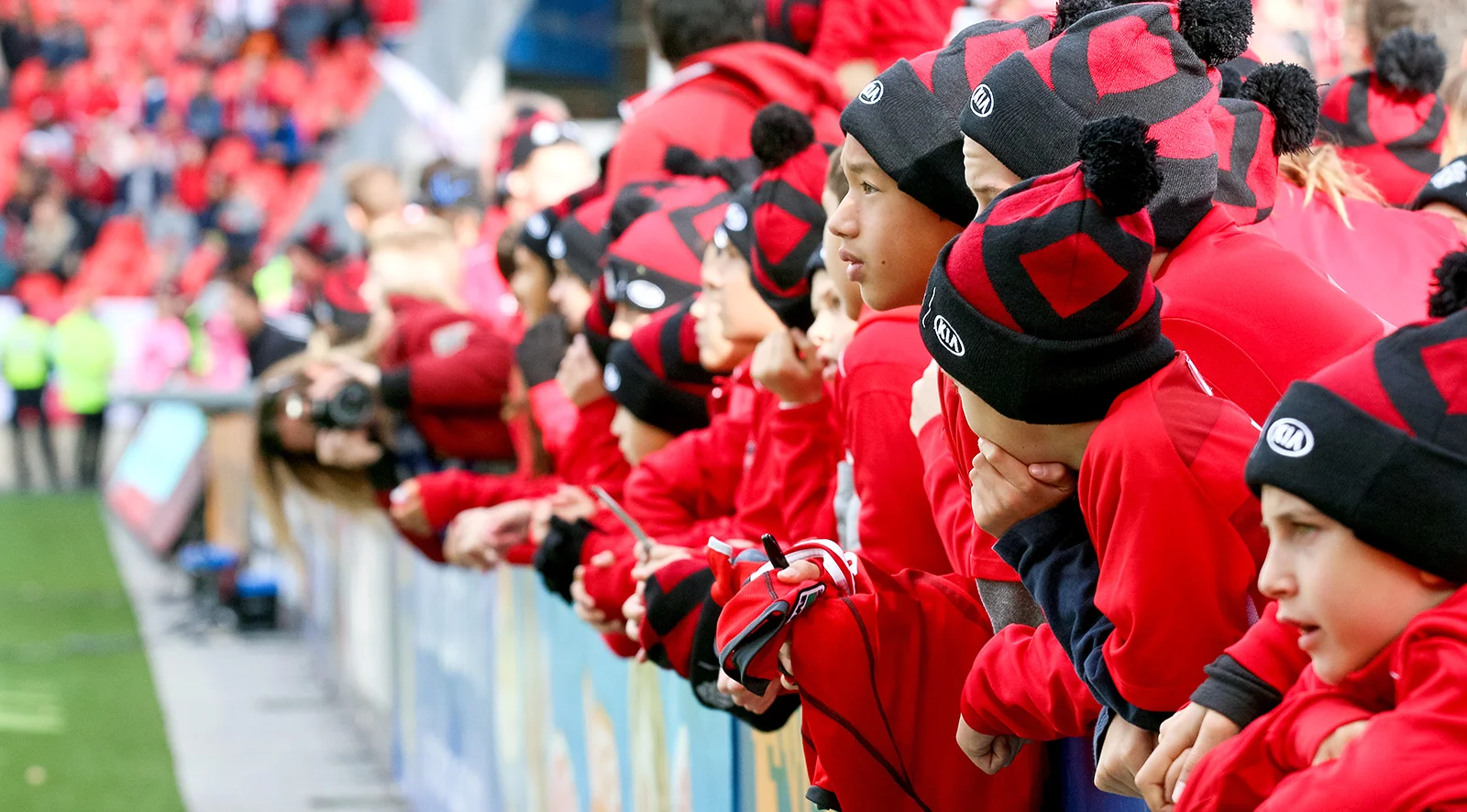 Young TFC fans watching the practice from the sidelines before the match begins.