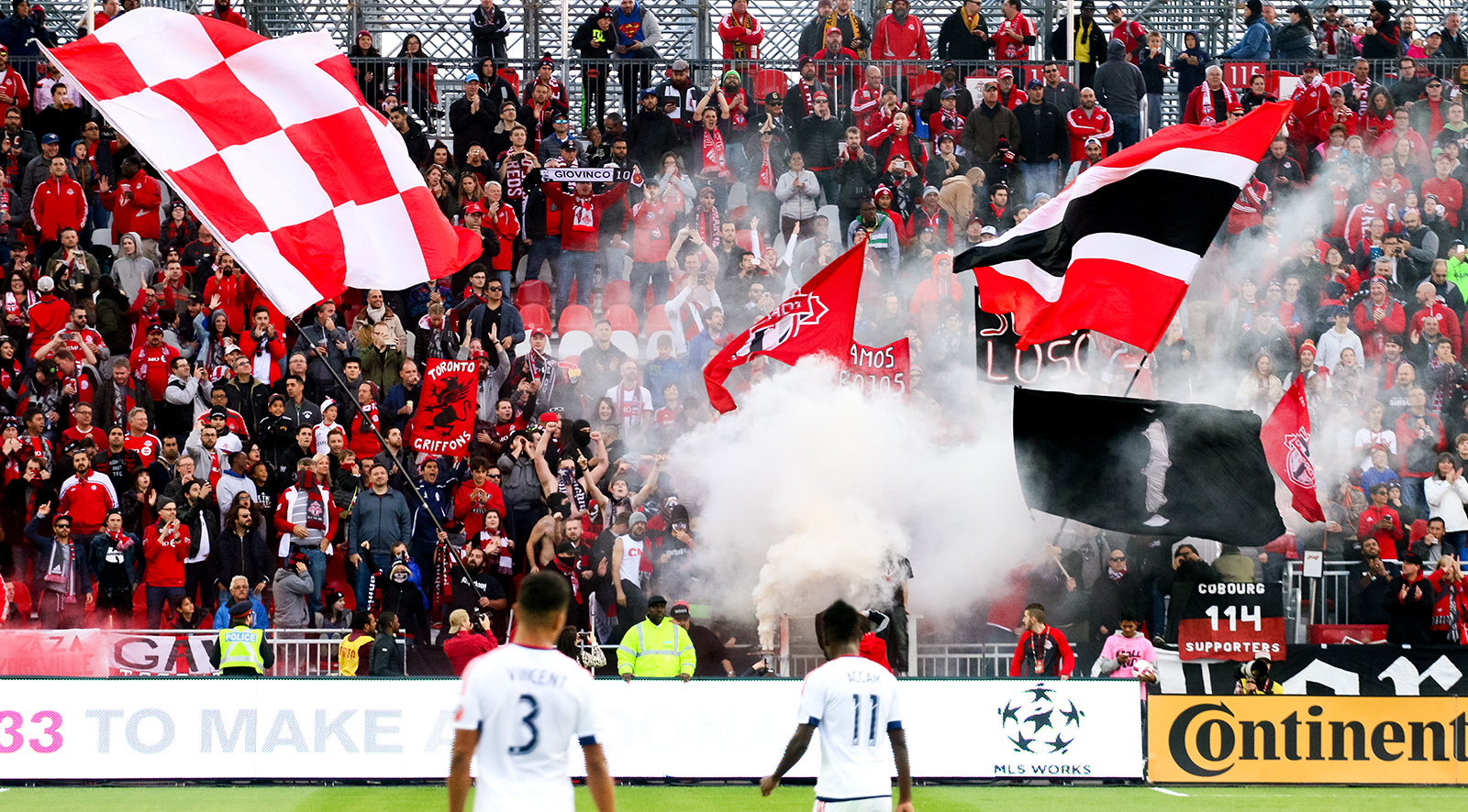 Toronto FC supporters doing their thing while two Chicago Fire players look on.