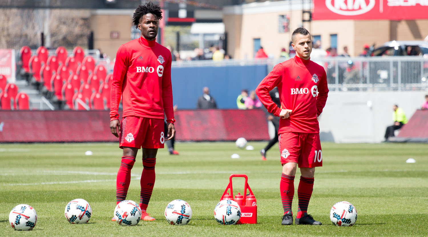 Tosaint Ricketts and Sebastian Giovinco wait to take shots on net during warm ups before a Major League Soccer match at BMO Field in 2017. Image by Dennis Marciniak of denMAR Media.