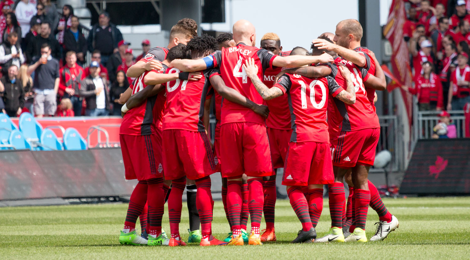Toronto FC's starting XI against Minnesota United in a huddle before a Major League Soccer match. Image by Dennis Marciniak of denMAR Media.