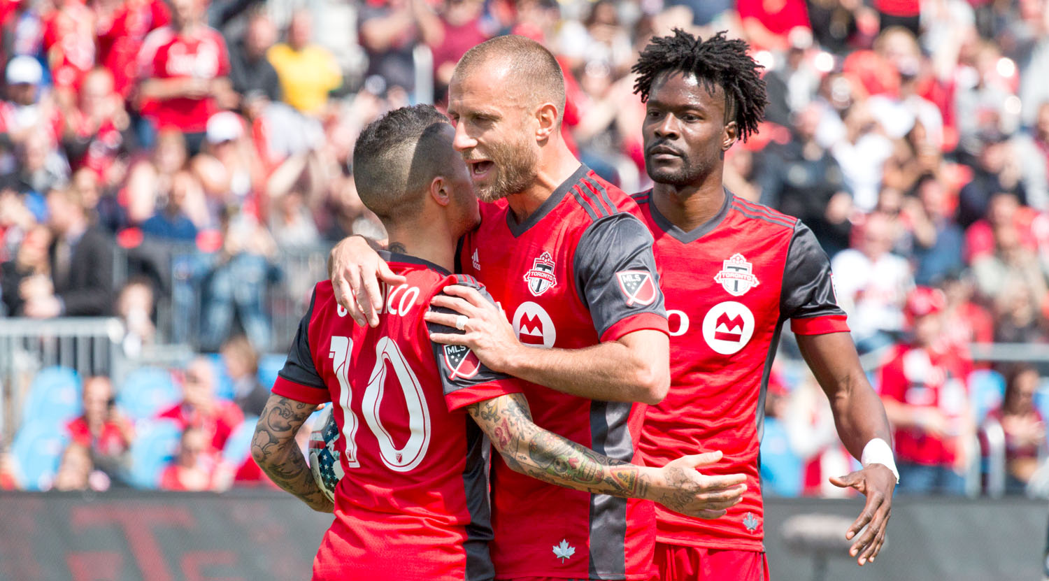 Benoît Cheyrou hugs Sebastian Giovinco after he converts the penalty kick to take Toronto FC to 1-0 in the first half. Image by Dennis Marciniak of denMAR Media.