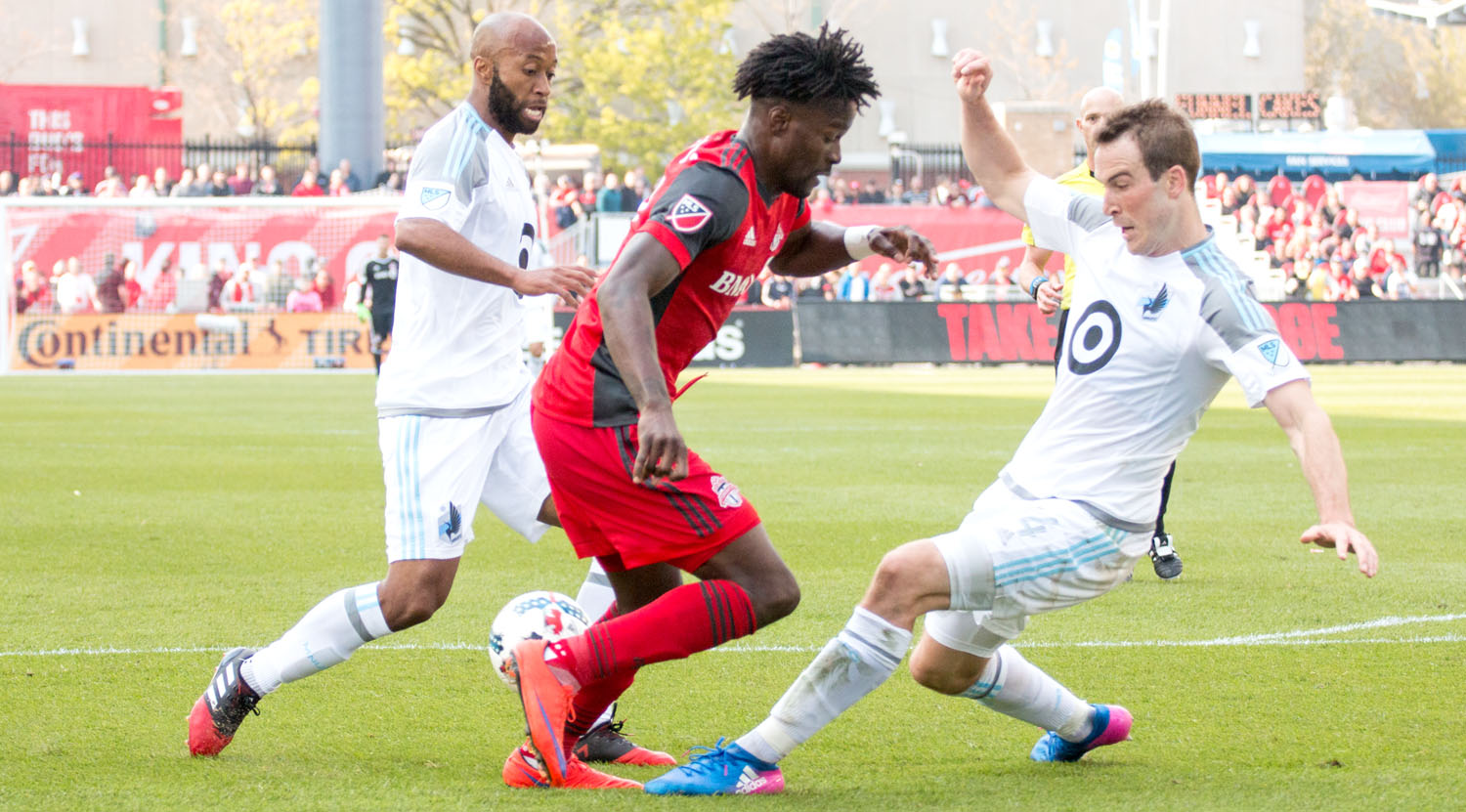 Tossaint Ricketts playing the ball around two Minnesota United FC players at BMO Field. Photo by Dennis Marciniak.