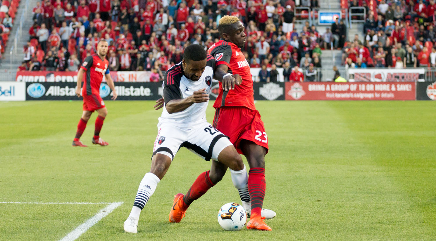 Chris Mavinga attempting to keep position of the ball against a Ottawa Fury defender during a game at BMO Field for the Canadian Championship in 2017. Image by Dennis Marciniak of denMAR Media.