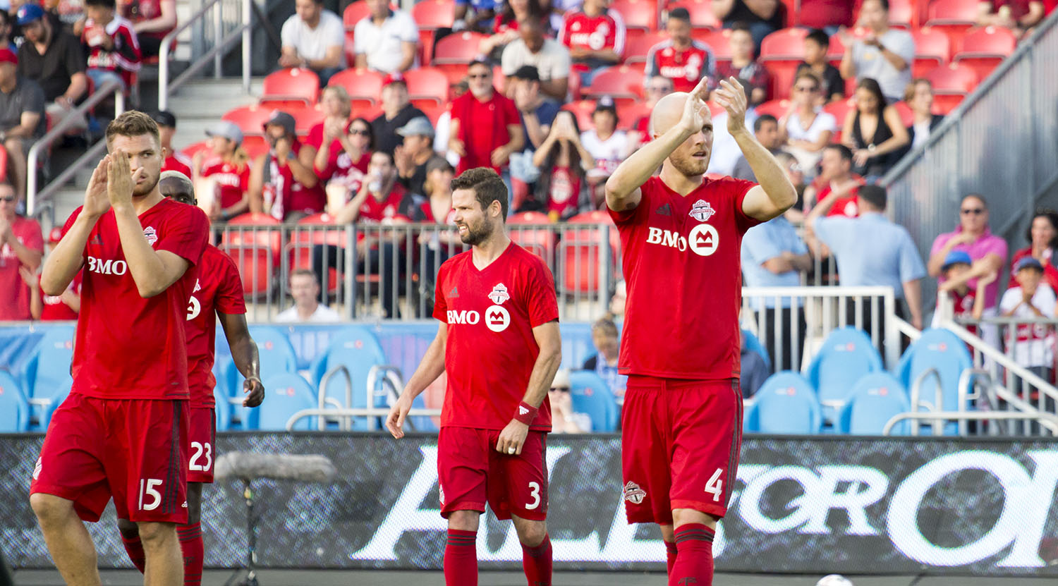 Drew Moor and Micheal Bradley give thanks to the south end supporter's section before a match. Image by Dennis Marciniak of denMAR Media.