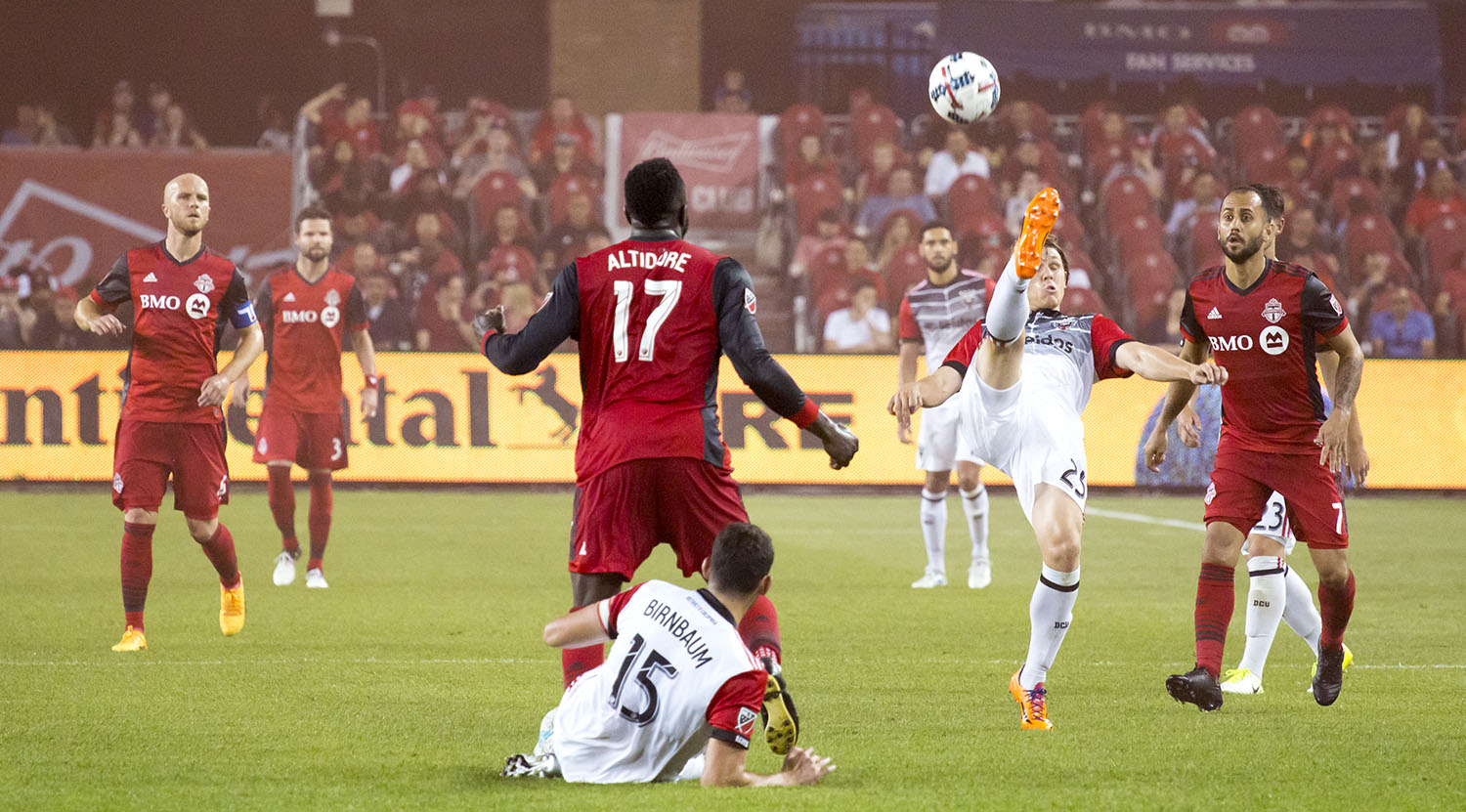 Toronto FC looks on as a DC United player tries to get the ball back into the the opposing half of the field. Image by Dennis Marciniak of denMAR Media.