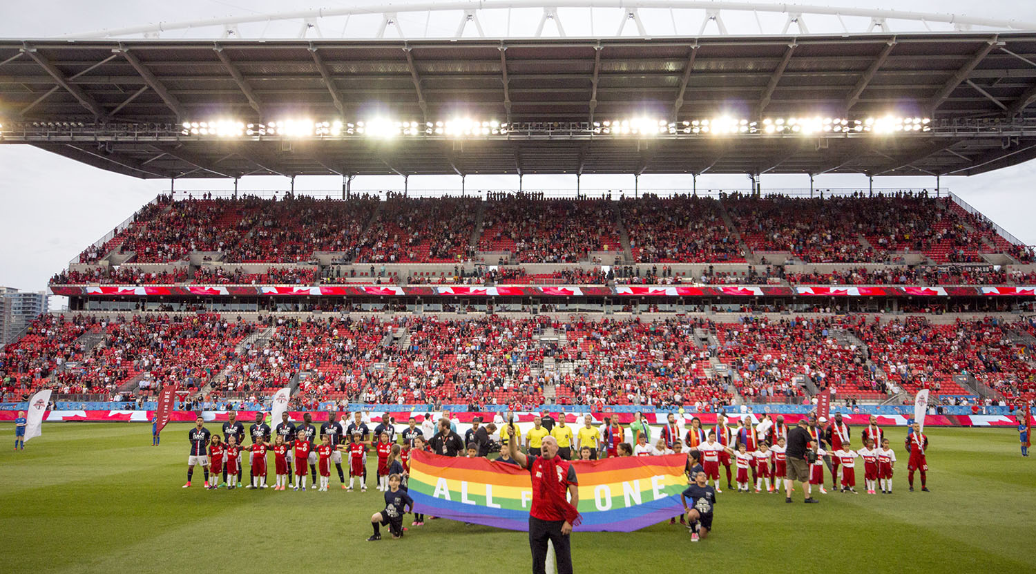The national anthem at BMO Field with Pride ceremonies taking place two nights ahead of the Pride Parade in Toronto, Canada. Image by Dennis Marciniak of denMAR Media.