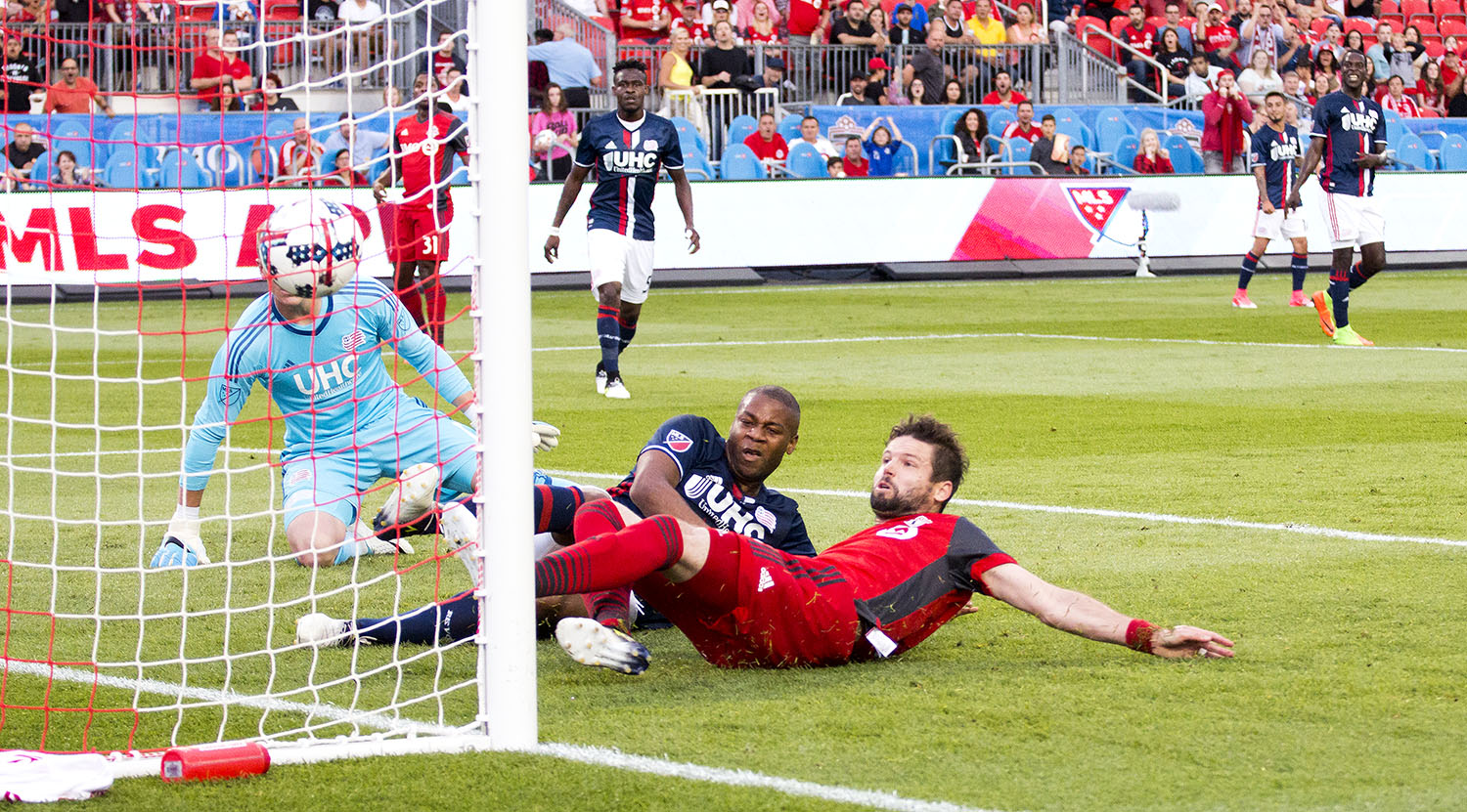 Drew Moor gets a ball across the box from Tsubasa Endoh and slides it past New England goalkeeper Cody Cropper to make it 1-0 in the first half of tonight's Toronto FC game. Image by Dennis Marciniak of denMAR