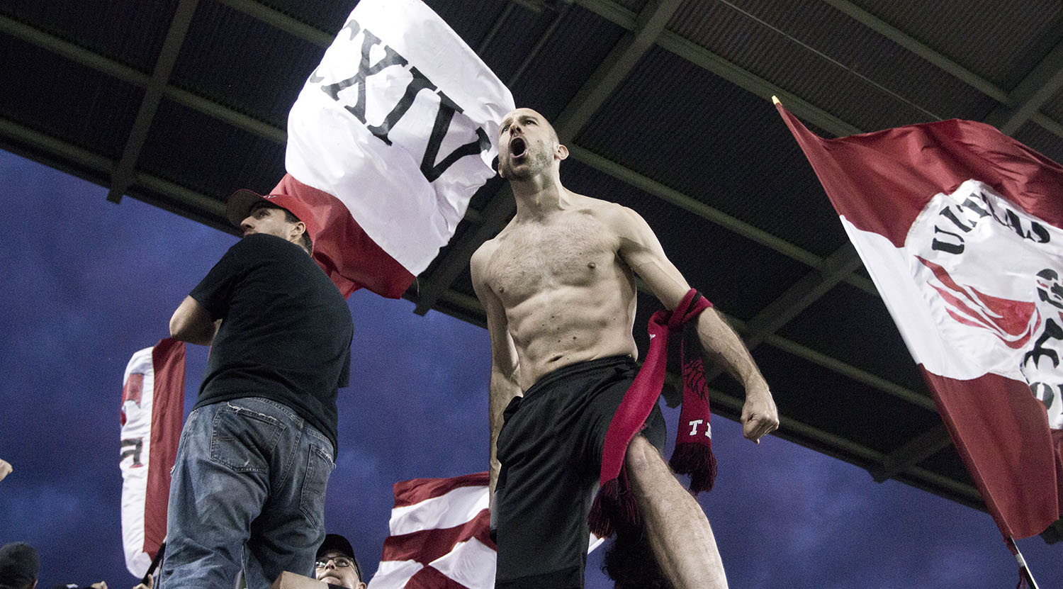 A fan in the south end supporter's section at BMO Field rallying all the other supporters around him to make some noise. Image by Dennis Marciniak of denMAR